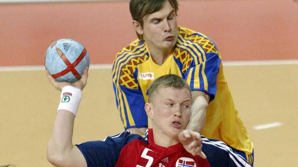 Norwegian Frank Loke (5) shoots to score as he is pushed by Swedish Martin Boquist (behind) during their match of the19th Men Handball World Championships, 01 February 2005 in the '7th November Hall" of Nabeul, Tunisia.  AFP PHOTO / ATTILA KISBENEDEK